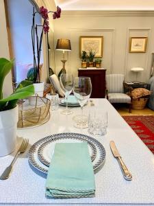 a table with a plate and glasses on a table at Old Riga Designer Luxury Apartment in Rīga