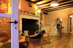 a living room with chairs and a fireplace at Le Jardin des Chouchoux in Brantôme