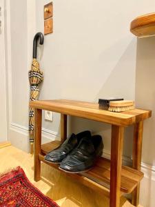 a wooden table with a pair of shoes and an umbrella at Old Riga Designer Luxury Apartment in Rīga