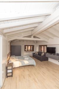 ein großes Schlafzimmer mit einem Bett und einem Sofa in der Unterkunft Appartamento Capriolo 28 - F&l Apartment in Brescia