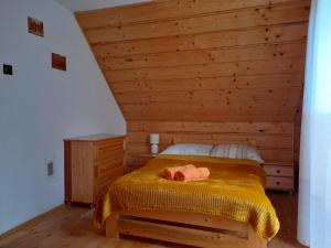 a bedroom with a bed with a wooden wall at U Eskulapa Bieszczady in Lutowiska