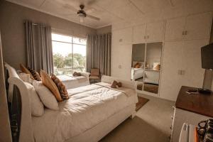 a bedroom with two beds and a large window at Selati 103 Guest Cottages in Malelane +78 photos
