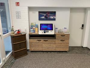 een kamer met een televisie op een houten dressoir bij Boardinghouse Breitscheid in Breitscheid