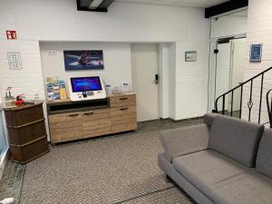 ein Wohnzimmer mit einem Sofa und einem Flachbild-TV in der Unterkunft Boardinghouse Breitscheid in Breitscheid