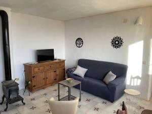 ein Wohnzimmer mit einem blauen Sofa und einem Tisch in der Unterkunft Apartamentos El Cabo in Mairena