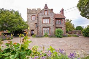 an old brick house with flowers in front of it at THE MOST CENTRAL Apartment in Canterbury Stunning Interiors, fully equipped, City Views and Free WiFi! in Kent