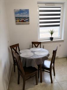 comedor con mesa, sillas y ventana en ŻYTNIA APARTAMENT KOSZALIN en Koszalin