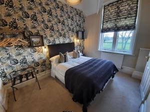a bedroom with a large bed and a large window at The Priory in Hereford