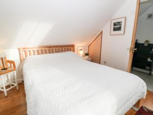 a bedroom with a white bed and a staircase at The Studio Loft in Tavistock