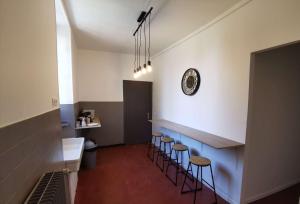 a bathroom with a bar with stools and a sink at Domaine de la Ferme de Jean Grogne in Fontenay-Trésigny