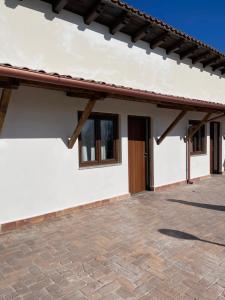 a white house with a brick patio at Agriturismo Monte Due Torri in Genzano di Roma