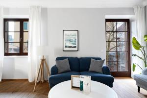 numa I Flute Apartments في سالزبورغ: غرفة معيشة مع أريكة زرقاء وطاولة