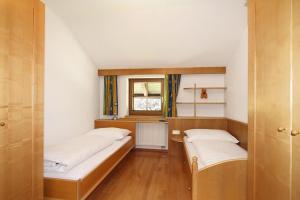 two beds in a small room with a window at Apartment Rössl Itter - OTR07519-RYA in Itter