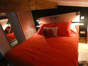 1 dormitorio con 1 cama con sábanas y almohadas rojas en L'Escale d'Aubagne, en Aubagne