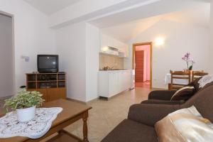 a living room with a couch and a tv at Apartment 5, first floor in Rogoznica