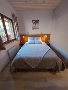 um quarto com uma cama grande num quarto com janelas em chambre les ormes em Enchastrayes