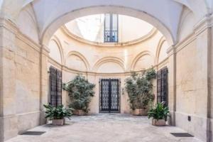 a large hallway with two potted plants in a building at Casa vacanze De Mari in Lecce