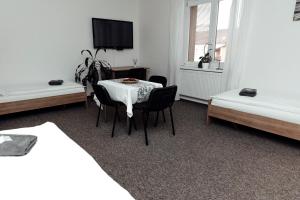 a room with a table and chairs and a tv at PENZION VERMON in Svitavy