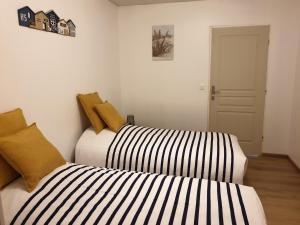 two beds in a small room withskirts at Gîte domaine de la galopade in Étréaupont