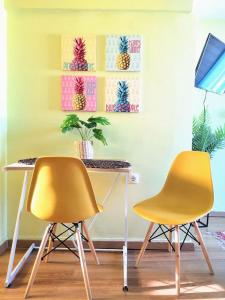 two yellow chairs and a desk with a table and a painting at Tropical Loft with View in Volos