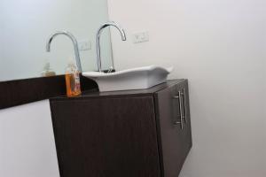 ein Waschbecken mit zwei Armaturen auf einem Schrank in der Unterkunft CASA VISTA HERMOSA in Baños + 52 Fotos