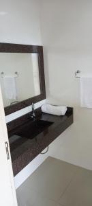 a bathroom with a sink and a mirror at Pousada Floresta in Joinville