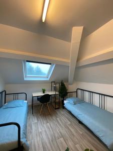 two beds in a room with a desk and a window at Capstay - Trith Netflix in Trith-Saint-Léger