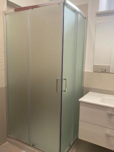 een glazen douche in een badkamer met een wastafel bij B&B VILLA LA GINESTRA in Boscoreale