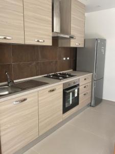 a kitchen with wooden cabinets and a stainless steel refrigerator at B&B VILLA LA GINESTRA in Boscoreale