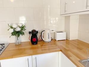 a kitchen counter with a toaster and flowers on it at Oxford city centre house/walkable to University in Oxford