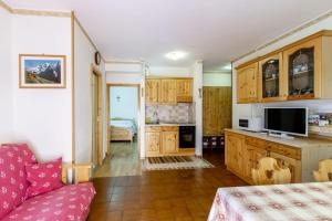 una cocina con armarios de madera y un sofá en una habitación en Solaia en Mazzin