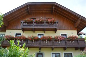 um edifício com uma varanda com flores em Appart Weisse Urlauben am Wolfgangsee em Sankt Gilgen