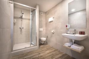 a bathroom with a shower and a sink and a toilet at Remisens Hotel EPIDAURUS in Cavtat