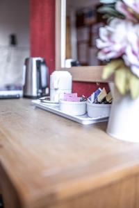 eine Theke mit einem Tablett mit Tellern und einer Vase mit Blumen in der Unterkunft The Watergate Inn in York