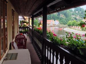 uma varanda com vista para um rio e flores em Pension Meandr em Cesky Krumlov