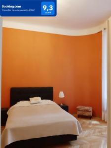 - une chambre avec un mur orange et un lit dans l'établissement Star Apartment City Center, à Łódź