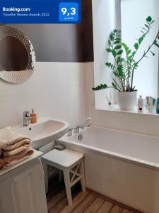 La salle de bains blanche est pourvue d'une baignoire et d'un lavabo. dans l'établissement Star Apartment City Center, à Łódź