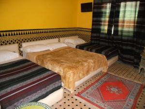 a room with a bed, a chair, and a lamp at Riad Passiflora in Fez