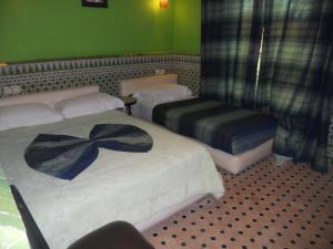 a hotel room with two beds and two lamps at Riad Passiflora in Fez