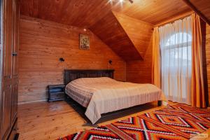 1 dormitorio con 1 cama en una habitación de madera en Floarea Bucovinei, en Vama