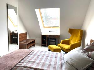 een slaapkamer met een bed en een gele stoel bij Lilie Appartement in Hévíz mit Tiefgarage, new and modern in Hévíz