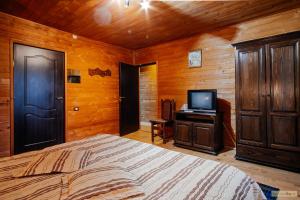 1 dormitorio con 1 cama y TV en Floarea Bucovinei, en Vama