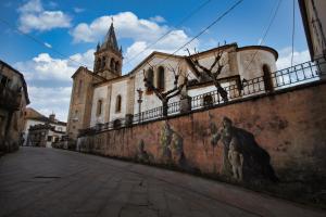 a wall with paintings on it next to a church at Pension Escalinata in Sarria