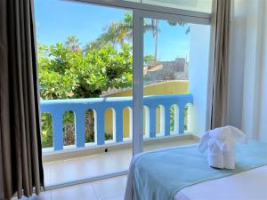 a room with a bed and a window with a view at Villas & Resort Luz de Luna in Santa Cruz Huatulco