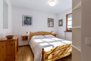 een slaapkamer met een houten bed en een houten dressoir bij El Tobià in Campitello