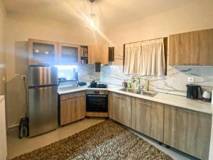 a kitchen with wooden cabinets and a stainless steel refrigerator at TM Apartment No 2 - Scandinavian Style in Aridaia