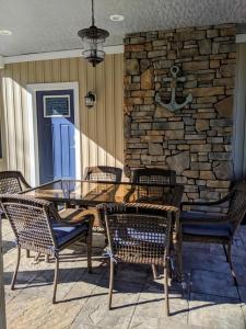 a table and chairs on a patio with a stone wall at Cardinal Road home in Mayville