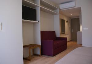 een woonkamer met een rode stoel en een televisie bij Aparthotel K in Figueres
