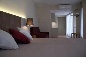 una camera da letto con un grande letto con cuscini rossi e bianchi di Aparthotel K a Figueres