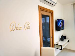 a white room with a door and a white chair at Deluxe Alba in Locorotondo